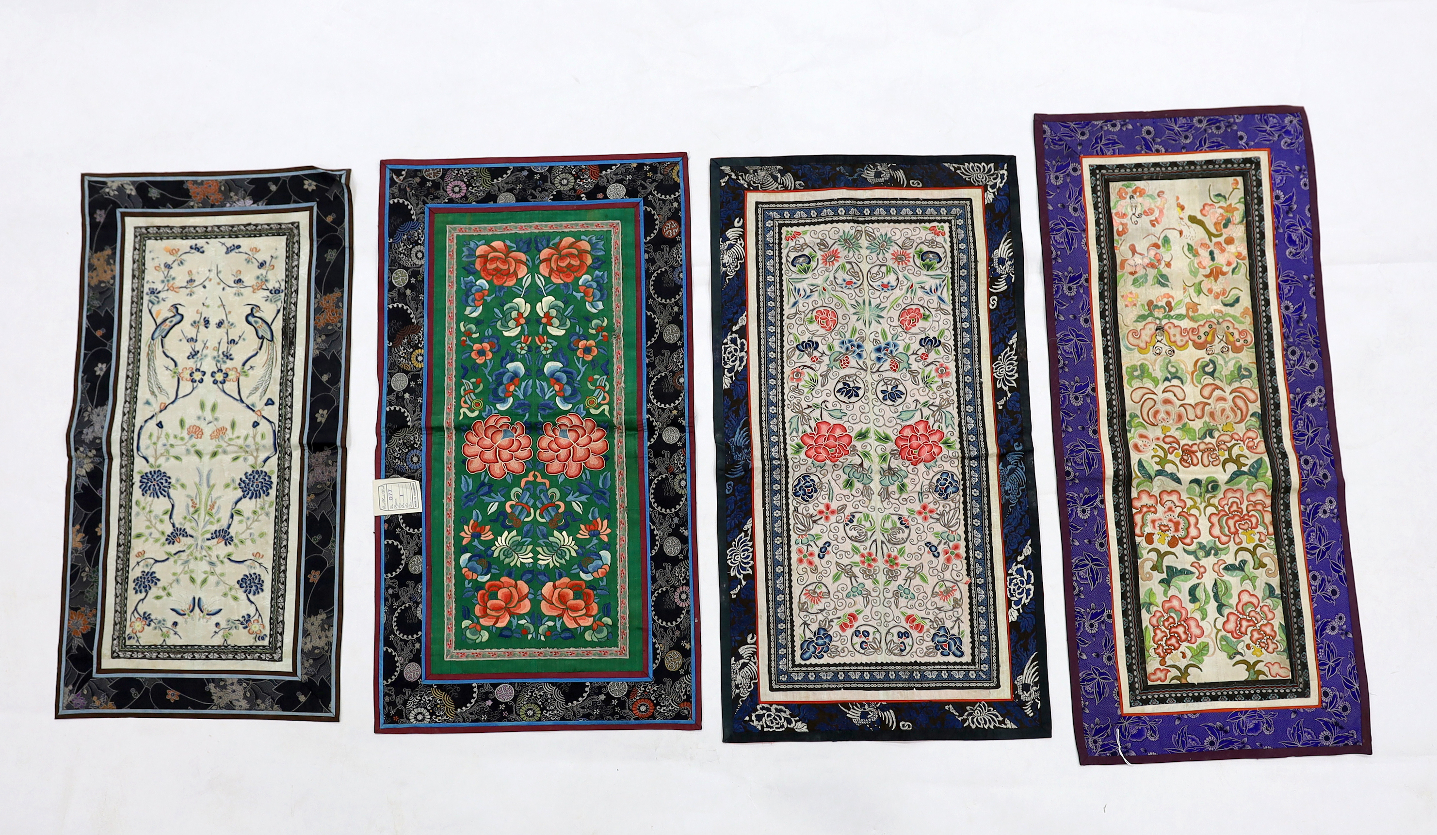 Three Beijing knot pairs of sleeve bands bordered with silk brocade and one pair embroidered with polychrome silks and gold thread longest, 73cm x 32cm including damask border